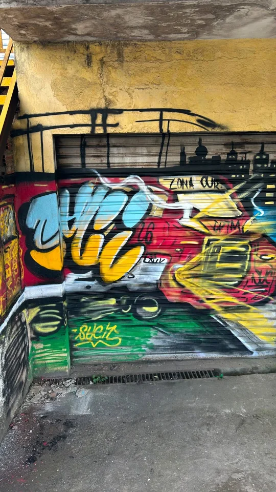 Graffiti colorido em porta de metal, em registro de trabalho coletivo