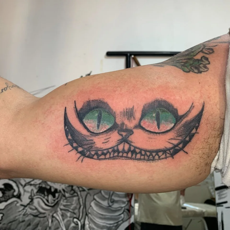 Tatuagem sombreada do Gato de Alice no braço
